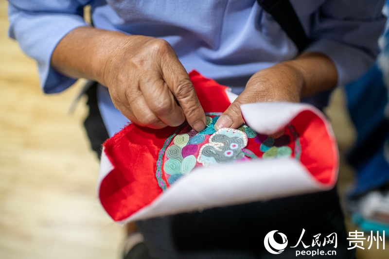 Une brodeuse travaille sur une pièce de broderie dans un atelier du comté de Taijiang, dans la province du Guizhou (sud-ouest de la Chine). (Weng Qiyu / Le Quotidien du Peuple en ligne)