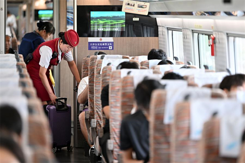 Une employée de la compagnie de chemin de fer en plein service à bord du train à grande vitesse G8844 reliant la municipalité de Tianjin, dans le nord de la Chine, à l
