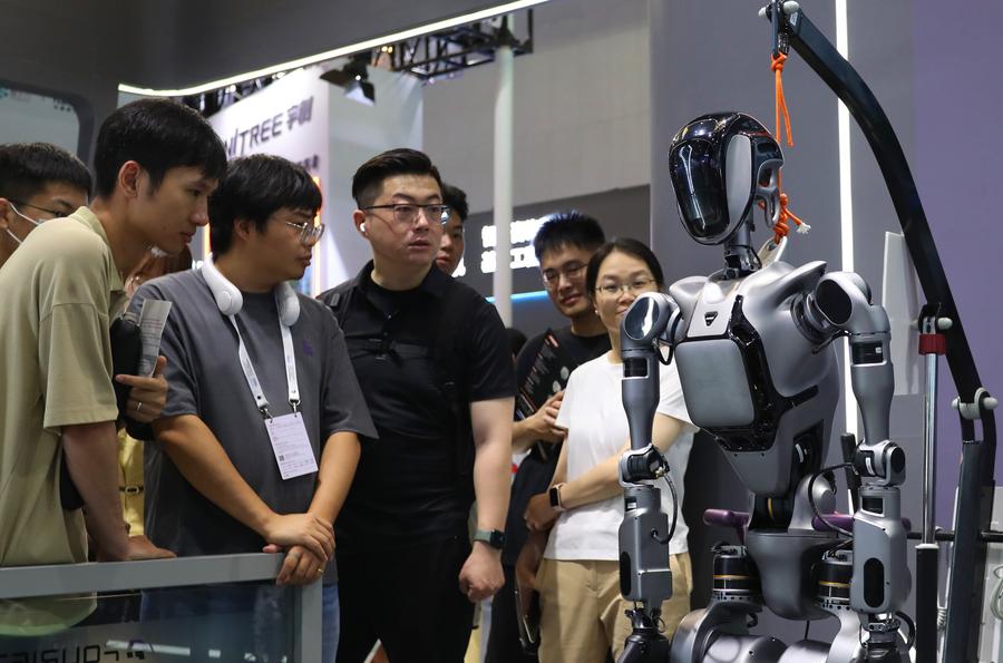 Des visiteurs observent un robot lors de la Conférence mondiale sur l'IA 2024 à Shanghai, dans l'est de la Chine, le 5 juillet 2024. (Photo : Fang Zhe)