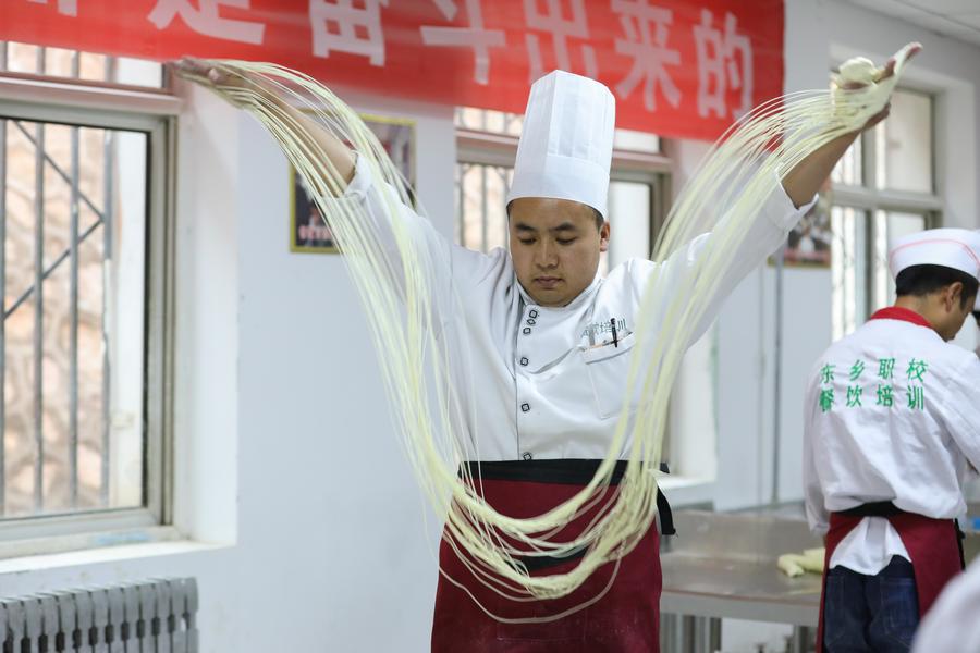 Un apprenti étire des nouilles à la main dans une école professionnelle du district de Dongxiang de la préfecture autonome Hui de Linxia, dans la province chinoise du Gansu (nord-ouest), le 28 mai 2020. (Photo : Ma Xiping)