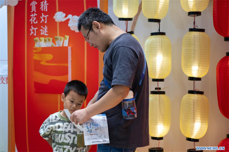 Des visiteurs déchiffrent des énigmes sur des lanternes lors d'un événement de la fête de la mi-automne au Salon international du commerce des services de Chine 2024 (CIFTIS), au parc Shougang, à Beijing, capitale chinoise, le 15 septembre 2024. (Xinhua/Li Xulun)