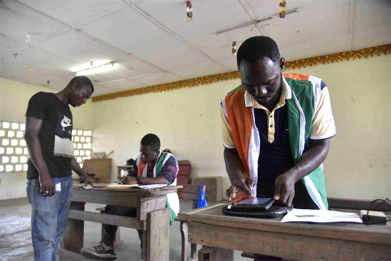 Des membres du personnel enregistrent les informations des électeurs dans un centre d'inscription à Abidjan, en Côte d'Ivoire, le 22 octobre 2024. (Xinhua/Yvan Sonh)