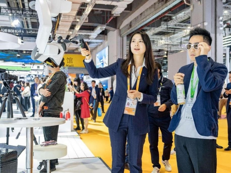 Des visiteurs expérimentent le microscope chirurgical robotisé au stand Zeiss dans la zone d'exposition des technologies et des équipements de la 6e CIIE, le 6 novembre 2023. (Zhai Huiyong / Pic.People.com.cn)