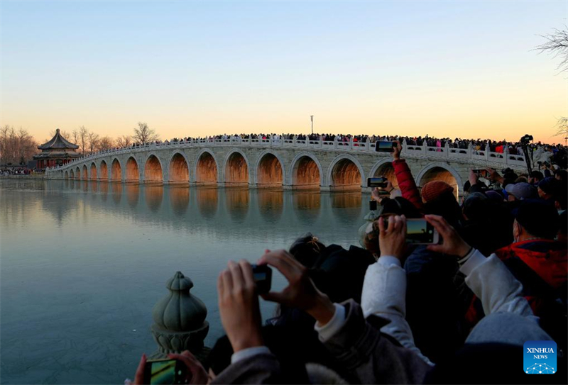 Beijing : des gens visitent le pont aux 17 Arches du Palais d'Été