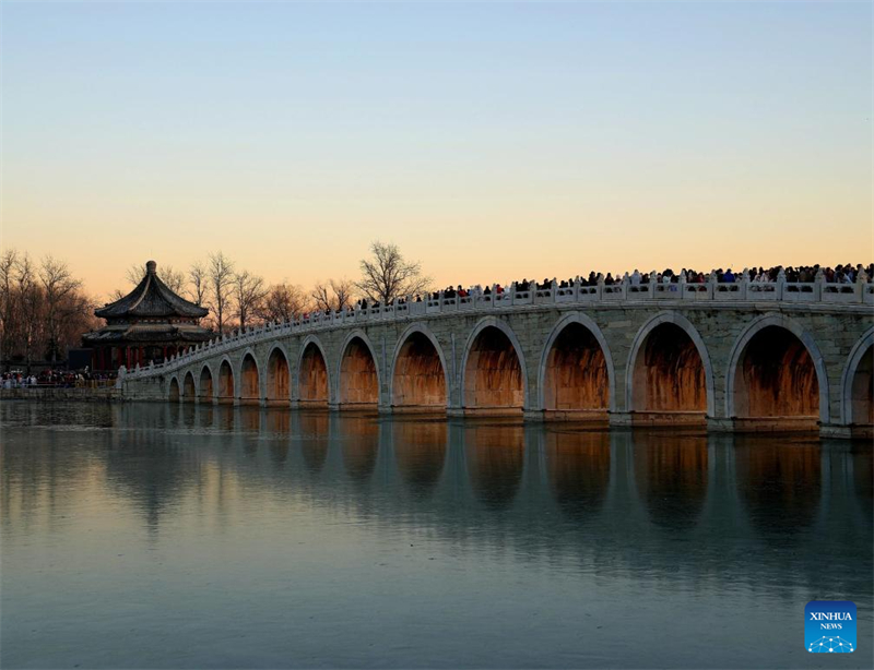 Beijing : des gens visitent le pont aux 17 Arches du Palais d'Été