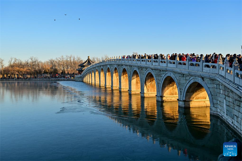 Beijing : des gens visitent le pont aux 17 Arches du Palais d'Été