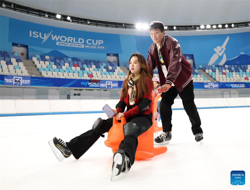 Les gens s'amusent avec de la glace et de la neige sur l'Anneau de patinage de vitesse de Beijing