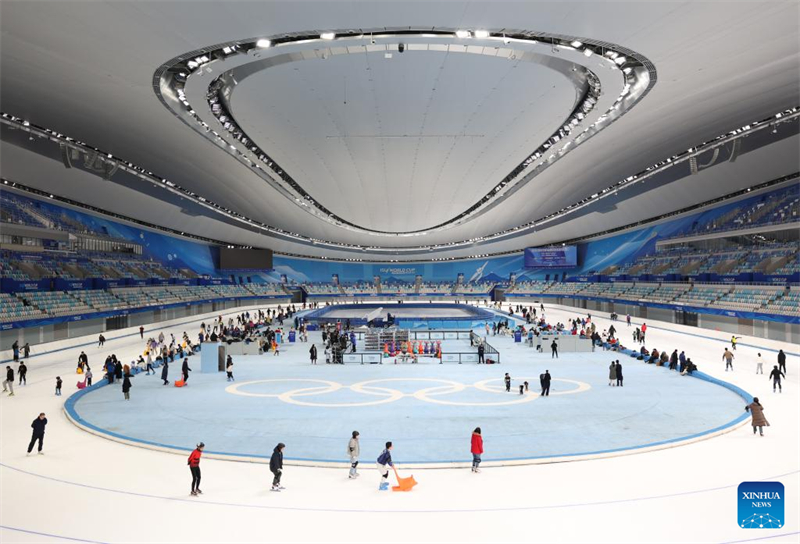 Les gens s'amusent avec de la glace et de la neige sur l'Anneau de patinage de vitesse de Beijing