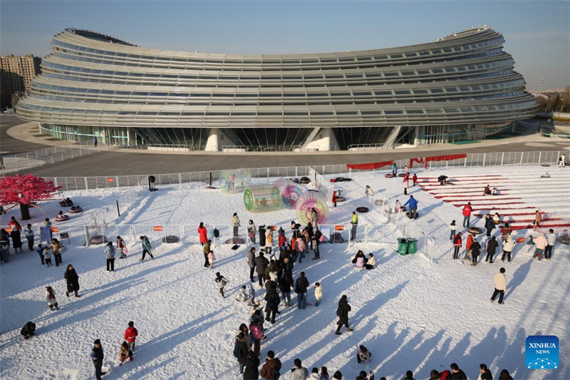 Les gens s'amusent avec de la glace et de la neige sur l'Anneau de patinage de vitesse de Beijing