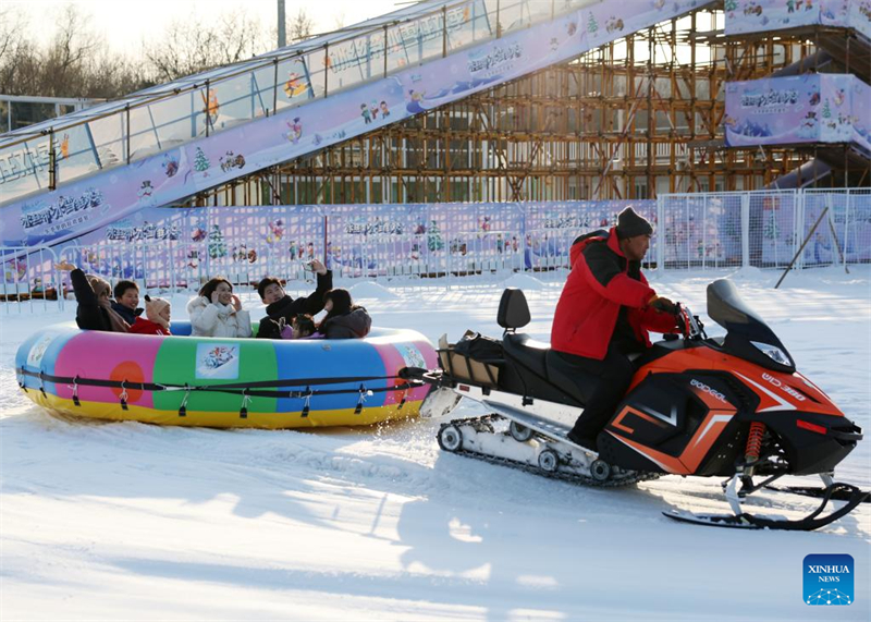 Les gens s'amusent avec de la glace et de la neige sur l'Anneau de patinage de vitesse de Beijing