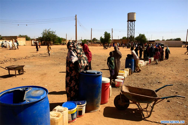 Des Soudanais font la queue pour obtenir de l'eau potable puisée dans un puits de la ville d'Omdourman, au nord de la capitale soudanaise Khartoum, le 18 janvier 2025. Depuis plus d'une semaine, Khartoum a connu des coupures d'électricité et d'eau, exacerbant la souffrance des citoyens qui attendent de longues heures devant des puits alimentés par des générateurs pour obtenir de l'eau potable. (Xinhua/Mohamed Khidir)