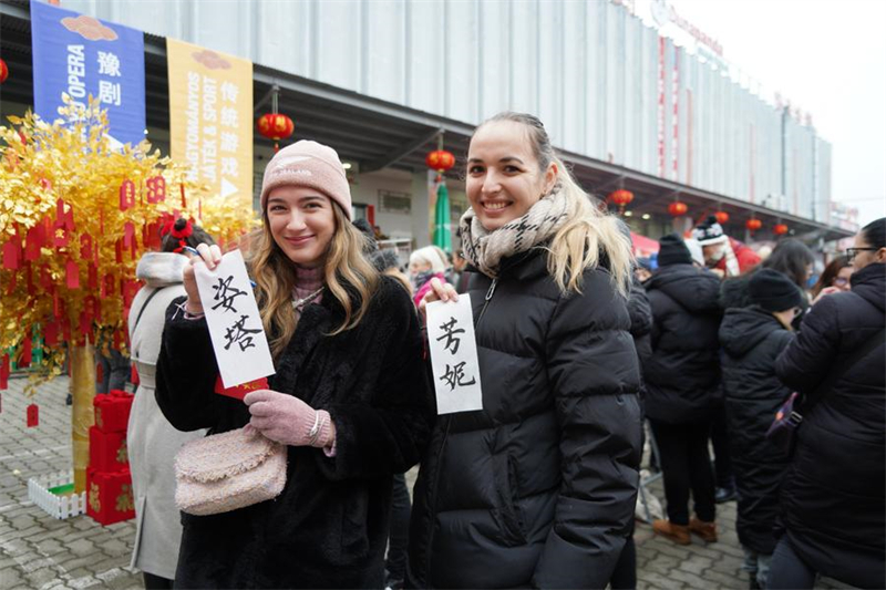 Deux filles montrent leurs noms écrits en calligraphie chinoise lors d'une foire du temple célébrant le Nouvel An chinois à Budapest, en Hongrie, le 18 janvier 2025. (Photo : Chen Hao)