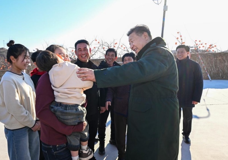 Xi Jinping prend le temps de discuter avec les membres d'une famille dans un village touché par les inondations à l'approche de la Fête du Printemps