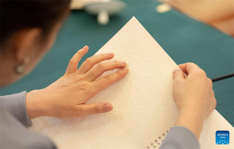 Le rapport d'activité du gouvernement en braille illustre les soins et le soutien de la Chine aux personnes handicapées