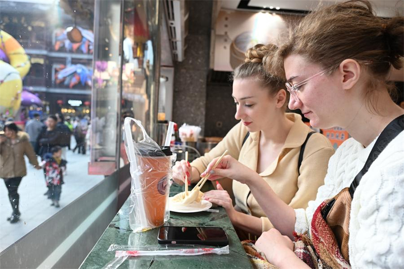 Deux touristes françaises dégustent des xiaolongbao (raviolis à la soupe) au centre commercial du jardin Yuyuan à Shanghai, dans l'est de la Chine, le 21 janvier 2025. (Photo : Chen Aiping)