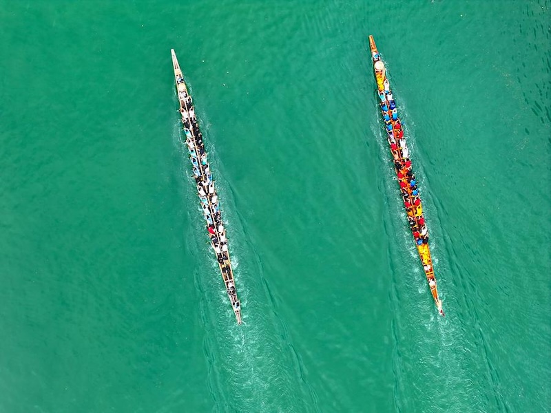 Une photo aérienne prise par un drone montre des habitants pagayant sur des bateaux-dragons dans la vielle ville de Zhenyuan, dans la préfecture autonome Miao et Dong de Qiandongnan, dans la province chinoise du Guizhou (sud-ouest), le 20 mai 2025. (Photo : Ou Dongqu)