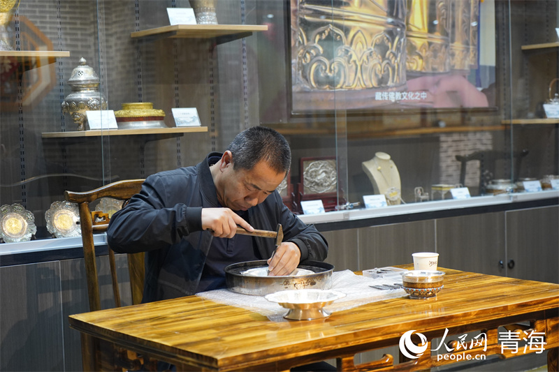 Wang Fubang fait une démonstration de compétences en artisanat de cuivre et d'argent et des techniques de dorure de Huangzhong dans une salle du patrimoine culturel intangible à Xining, capitale de la province du Qinghai (nord-ouest de la Chine). (Ma Kexin / Le Quotidien du Peuple en ligne)