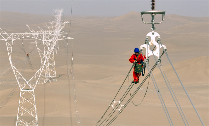Xinjiang : des ouvriers électriciens corrigent les défauts du réseau avant sa mise en service dans le désert à Qiemo