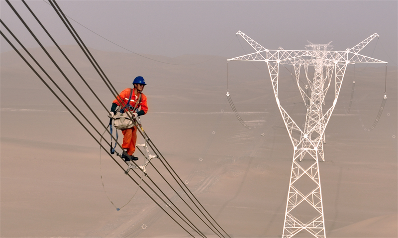 Xinjiang : des ouvriers électriciens corrigent les défauts du réseau avant sa mise en service dans le désert à Qiemo