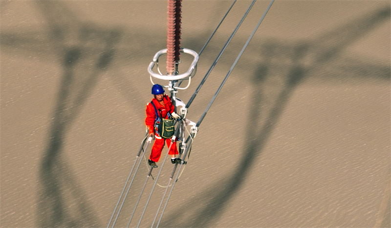 Xinjiang : des ouvriers électriciens corrigent les défauts du réseau avant sa mise en service dans le désert à Qiemo