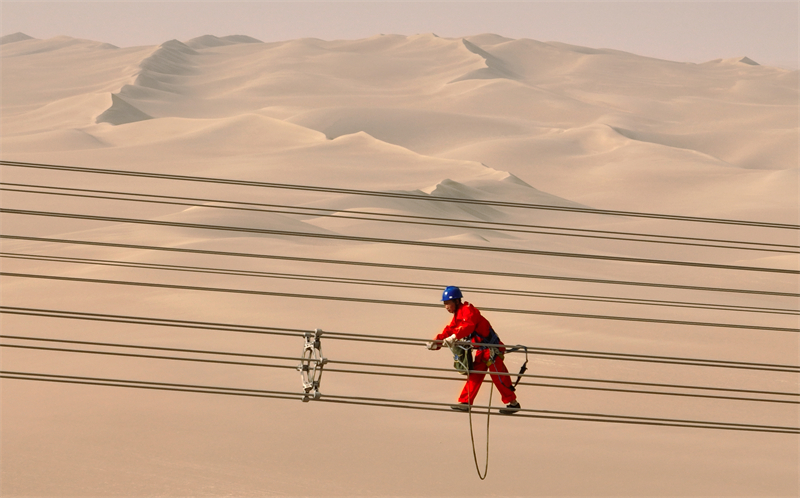 Xinjiang : des ouvriers électriciens corrigent les défauts du réseau avant sa mise en service dans le désert à Qiemo