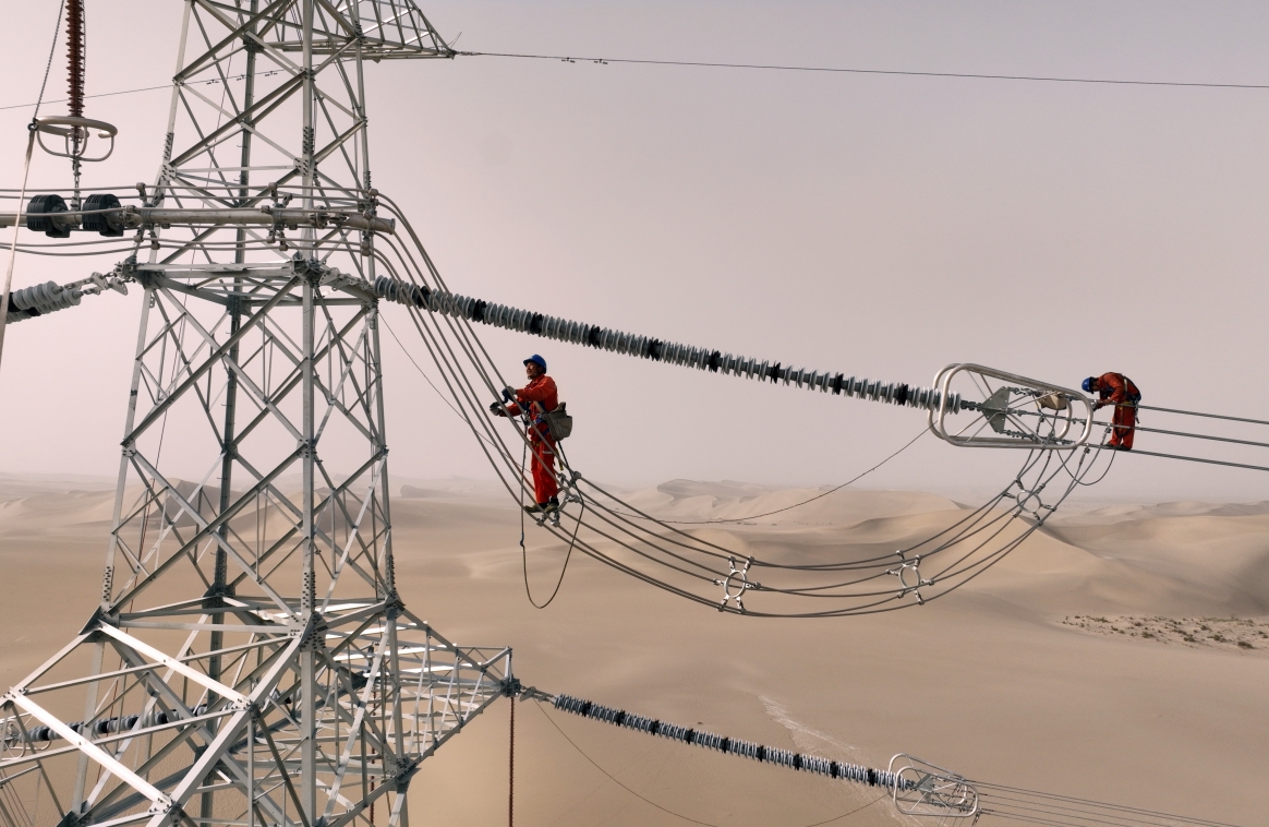 Xinjiang : des ouvriers électriciens corrigent les défauts du réseau avant sa mise en service dans le désert à Qiemo