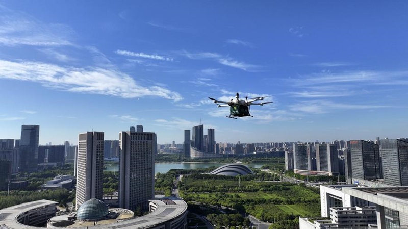 Photo aérienne prise le 20 août 2025 montrant un drone qui livre un colis au-dessus de l'arrondissement de Shushan, dans la ville de Hefei de la province de l'Anhui, dans l'est de la Chine. (Photo : Huang Bohan)