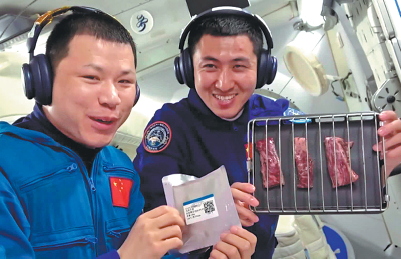Le colonel Wang Jie (à gauche), membre de l’équipage de Shenzhou XX, et le major Wu Fei, ingénieur de vol spatial de Shenzhou XXI, s’apprêtent à griller une assiette de steaks au poivre noir dans un four spécialement conçu à cet effet, livré par le vaisseau Shenzhou XXI, à bord de la station spatiale chinoise Tiangong, le 4 novembre. (Photo/CGTN)