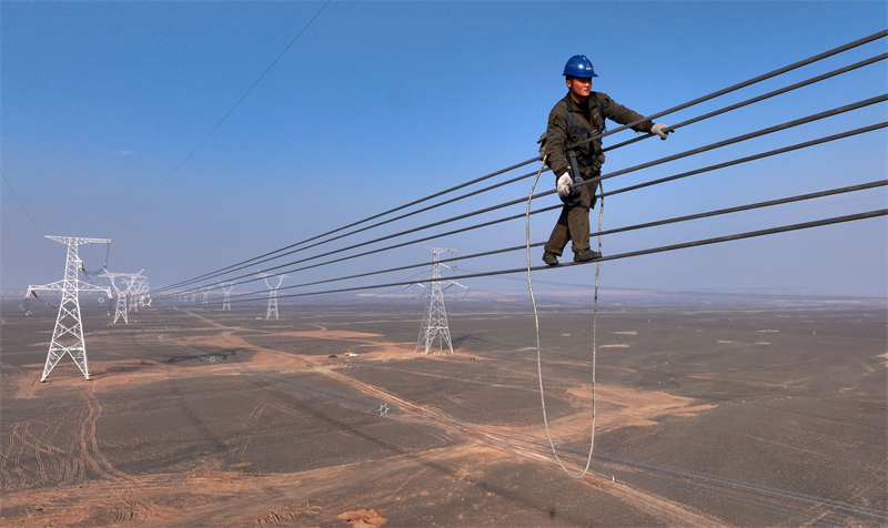 Xinjiang : des techniciens inspectent les lignes électriques en altitude pour éliminer les défauts à Qitai