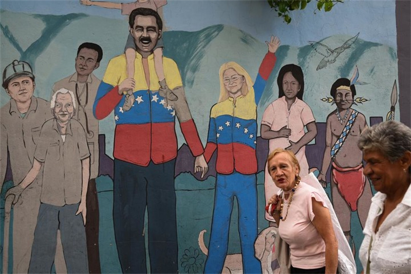 Des gens passent devant une fresque murale à Caracas, au Venezuela, le 5 novembre 2025. (Xinhua/Marcos Salgado)