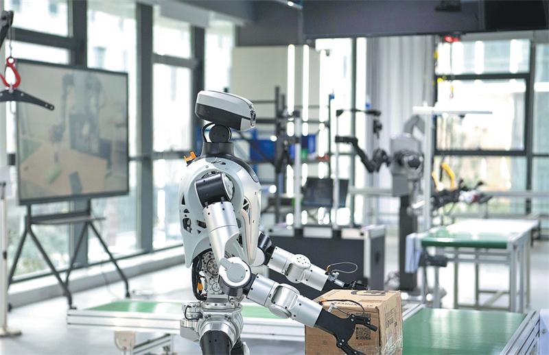 Un robot humanoïde suit une formation au transport de boîtes dans un centre de pré-formation à la collecte de données pour robots humanoïdes à Hefei, capitale de la province de l'Anhui (est de la Chine), le 4 décembre. (Zhang Duan/Xinhua)