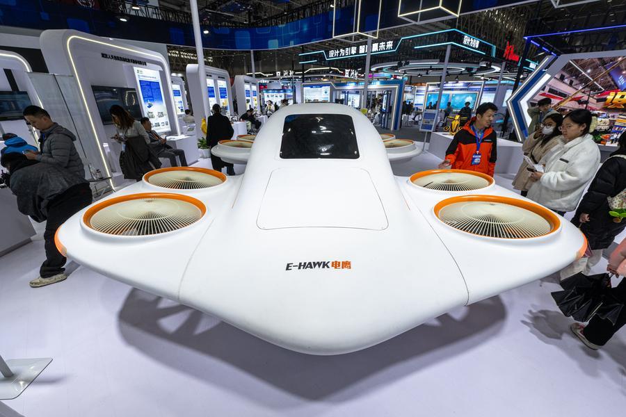 Des gens découvrent un drone à ventilateur canalisé lors de l'Exposition internationale de design industriel de Wuhan 2025, à Wuhan, capitale de la province du Hubei (centre de la Chine), le 12 décembre 2025. (Xiao Yijiu / Xinhua)