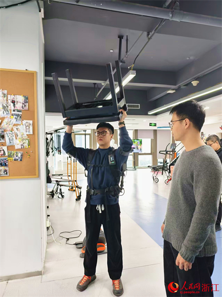 Un homme essaie un robot exosquelette de manutention industrielle lors d'un événement commercial sur la place Wushan à Hangzhou, dans la province du Zhejiang (est de la Chine). (Kang Mengqi/Quotidien du Peuple en ligne)