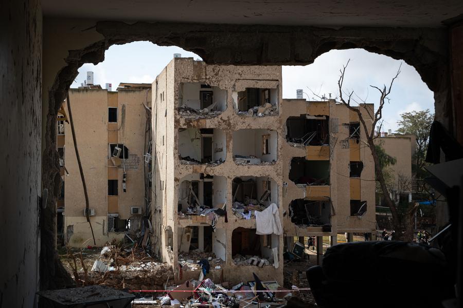 Photo prise le 22 mars 2026 montrant les débris d'un bâtiment endommagé après une frappe de missile à Arad, en Israël. (Xinhua/Chen Junqing)