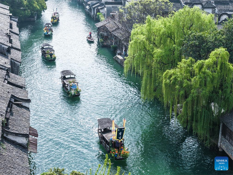 Photo aérienne prise par un drone le 1er avril 2026 montrant un défilé de bateaux lors d'une foire populaire à Wuzhen, dans la ville de Tongxiang, dans la province du Zhejiang (est de la Chine). (Xu Yu/Xinhua)