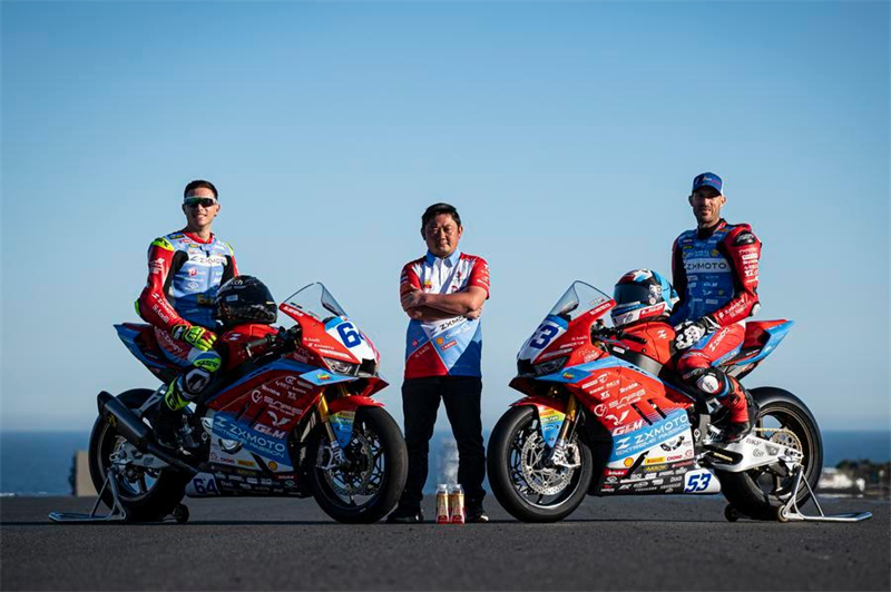 Le pilote français Valentin Debise (à droite) et le pilote italien Federico Caricasulo (à gauche) posent aux côtés de Zhang Xue (au centre), fondateur et propriétaire de la marque chinoise de motos ZXMOTO, sur le circuit du Grand Prix de Phillip Island, en Australie, le 20 février 2026. (Xinhua) 