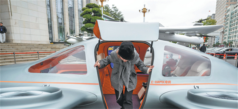 Un visiteur descend d'un avion électrique à décollage et atterrissage vertical exposé à Wuhan, capitale de la province du Hubei (centre de la Chine), le 24 février. (Xiao Yijiu/Xinhua)