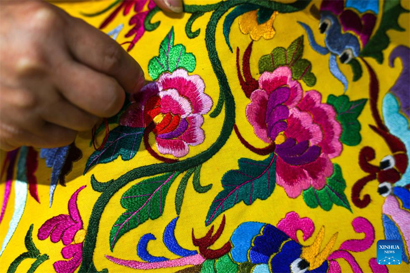 Une villageoise travaille sur une œuvre de broderie dans le village Dong de Zhaoxing, dans le comté de Liping de la province du Guizhou (sud-ouest de la Chine), le 21 avril 2026. (Yang Wenbin/Xinhua)