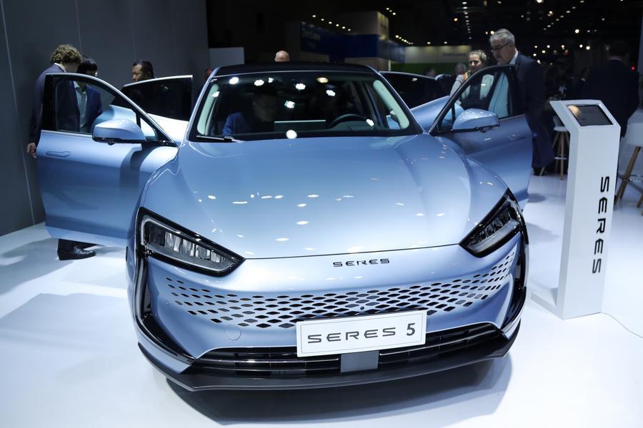 Des personnes essaient une voiture électrique Seres 5 lors d'une avant-première pour les médias du 100e Salon de l'automobile de Bruxelles, en Belgique, le 13 janvier 2023. (Xinhua/Zheng Huansong)