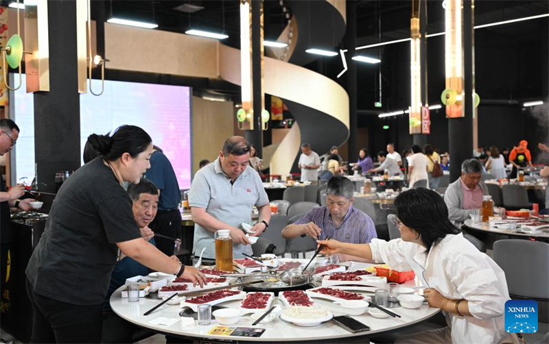 Des gens dégustent une fondue de bœuf dans un restaurant de fondue de bœuf à Chaozhou, dans la province du Guangdong (sud de la Chine), le 14 mai 2026. (Deng Hua/Xinhua)