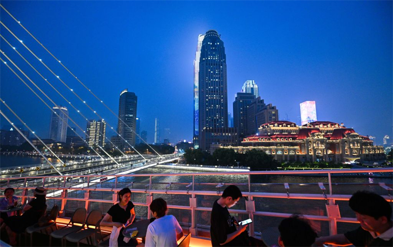 Des gens admirent la vue nocturne sur la rivière Haihe depuis un complexe commercial et de loisirs situé près du pont Chifeng sur la rivière Haihe, à Tianjin, dans le nord de la Chine, le 19 juin 2026. (Photo : Zhao Zishuo)
