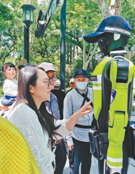 Une touriste demande son chemin au robot de contrôle de la circulation sur le site touristique du lac de l'Ouest à Hangzhou, capitale de la province du Zhejiang (est de la Chine). (Photo / Zhou Han)