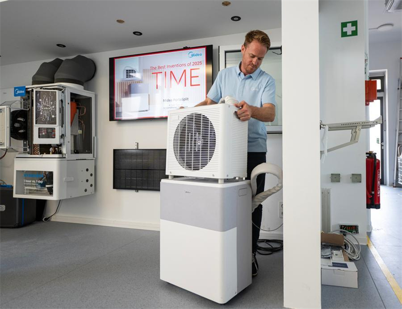 Tobias Strobel, responsable de l'innovation technique pour la climatisation résidentielle au centre de R&D allemand de Midea, présente l'installation du climatiseur split mobile PortaSplit de Midea à Stuttgart, en Allemagne, le 30 juin 2026. (Zhang Haofu/Xinhua)