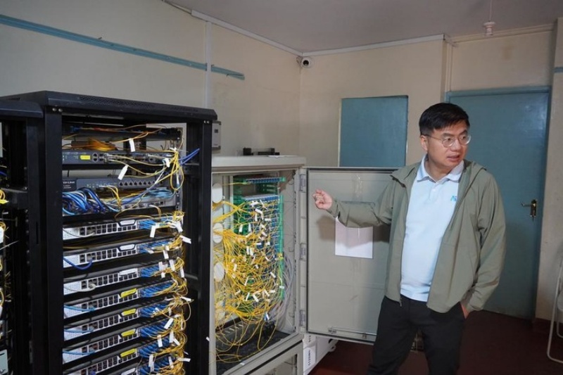 Zhou Tao présente la configuration du système dans un centre d'accès au réseau communautaire, qui fournit des services Internet par fibre optique à plus de 18.000 foyers dans le quartier de Kibera, à Nairobi, au Kenya, le 10 juillet 2026. (Xinhua/Lu Zexin)