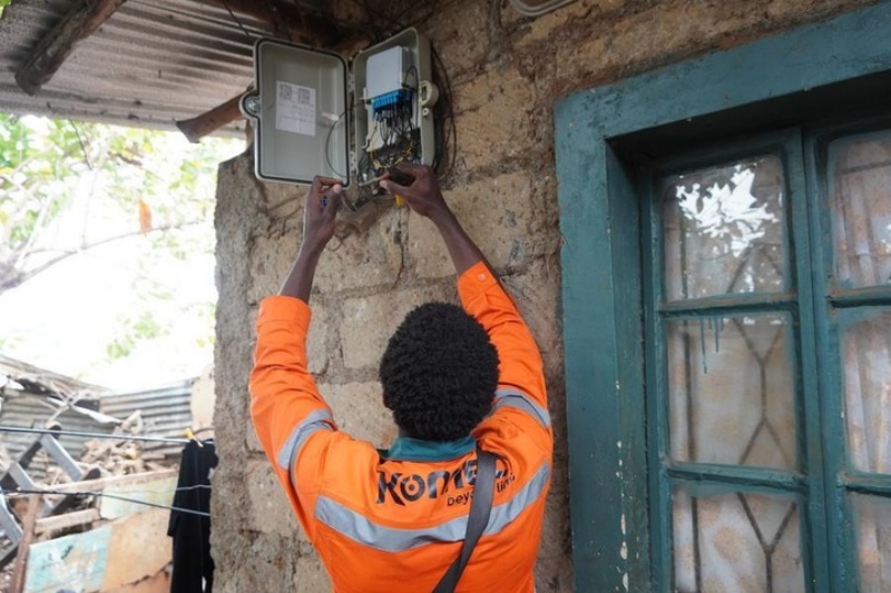 Un technicien réseau installe un câble à fibre optique reliant un boîtier de distribution à fibre optique au domicile d'un client à Kibera, à Nairobi, au Kenya, le 10 juillet 2026.