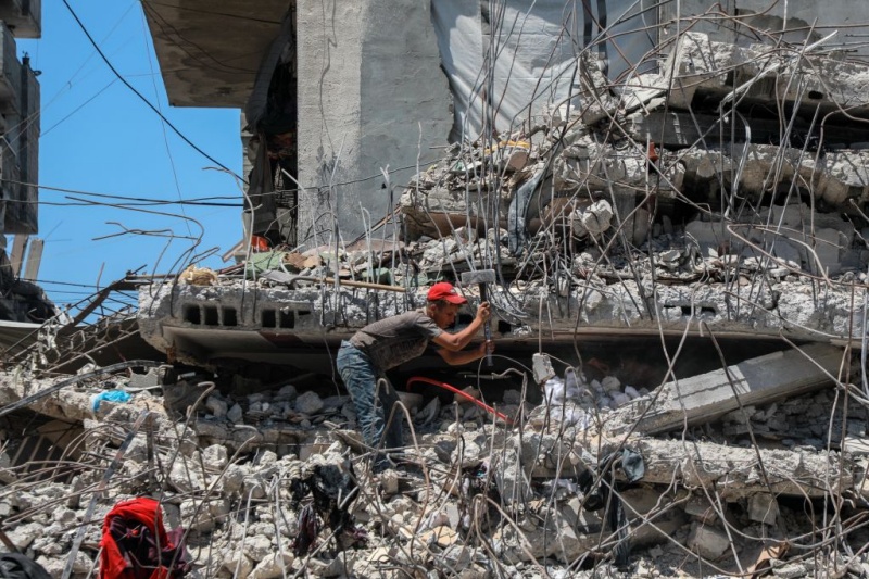 Un Palestinien récupère des barres de fer dans les décombres de maisons détruites à Gaza, le 18 août 2026, alors que la bande de Gaza connaît une pénurie de matériaux de construction. (Xinhua/Rizek Abdeljawad)