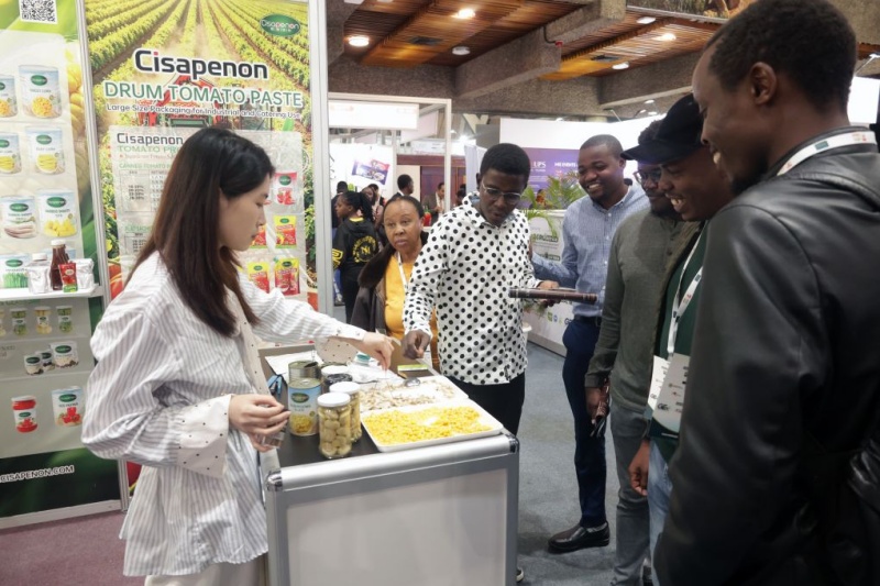 Une exposante (à gauche) propose des dégustations aux visiteurs lors du Salon africain de l'alimentation (Africa Food Show) dans le Centre international de conférence Kenyatta (KICC) à Nairobi, la capitale du Kenya, le 20 août 2026. (Xinhua/John Okoyo)