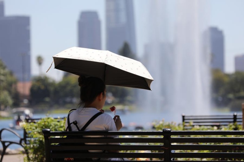 Une femme mange de la pastèque en pleine vague de chaleur dans un parc de Los Angeles, en Californie, aux Etats-Unis, le 1er août 2026. (Xinhua/Zeng Hui)