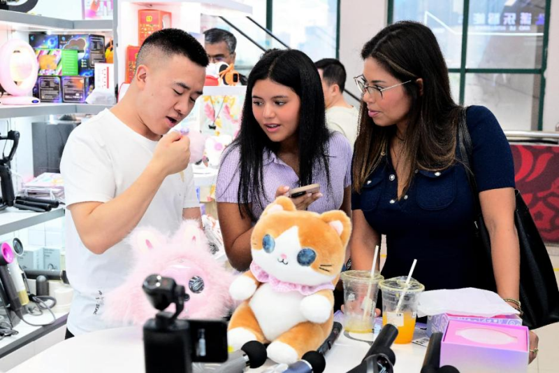 Des hommes d'affaires étrangers négocient l'achat de jouets intelligents et interactifs à Yiwu, dans la province du Zhejiang (est de la Chine). (Photo/Shi Bufa)
