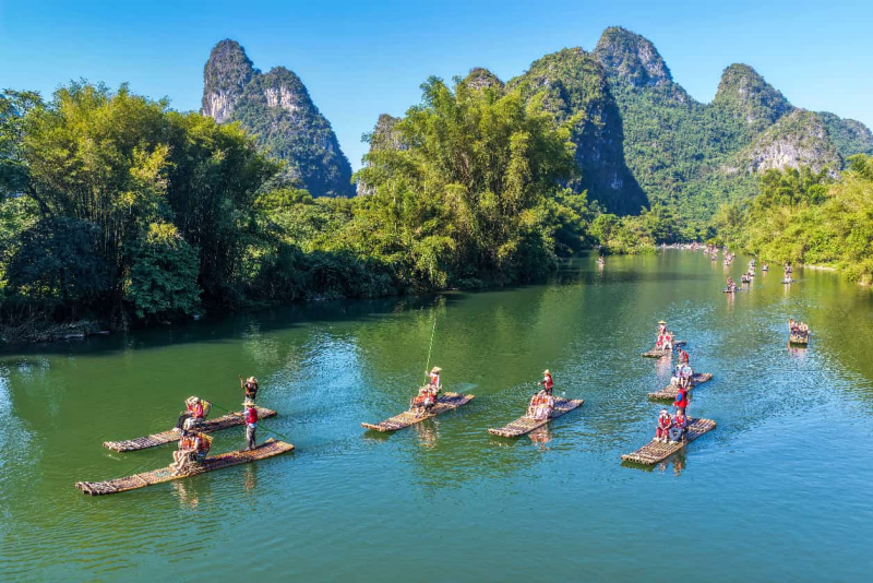 Des touristes profitent du paysage fluvial à bord de radeaux en bambou dans la zone touristique de la rivière Yulong, dans le district de Yangshuo de la ville de Guilin, dans la région autonome Zhuang du Guangxi (sud de la Chine), le 7 octobre 2026. (Jiang Keqing / Pic.people.com.cn)